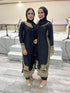 Two women wearing elegant black qameez with gold embroidery, showcasing traditional attire perfect for formal occasions.